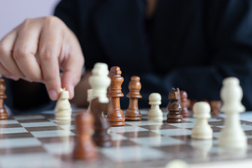 Close up shot hand of business woman playing the chess board to win by killing the king of opponent metaphor business competition winner and loser select focus shallow depth of field