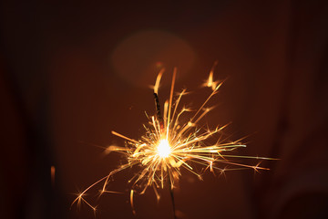Hand of woman holding firework firework pyrotechnics and bokeh with blurry effect on the dark background for celebration concept