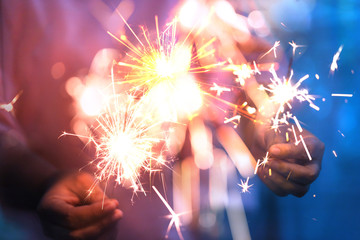 Hand of woman holding firework firework pyrotechnics and bokeh with blurry effect on the dark...