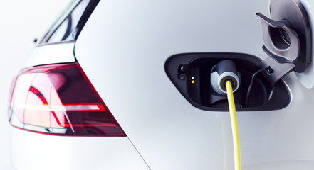 Close Up Of Power Cable Charging Environmentally Friendly Zero Emission Electric Car In Garage