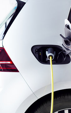Close Up Of Power Cable Charging Environmentally Friendly Zero Emission Electric Car In Garage