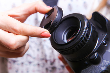 Photographer puts cap on lens of camera