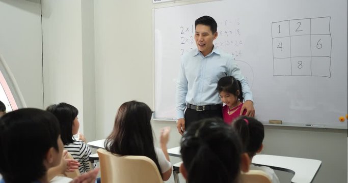 Asian teacher introduces new students in the class at school. Little boy and girl has new friend together. Concept of education, presentation and friendly.