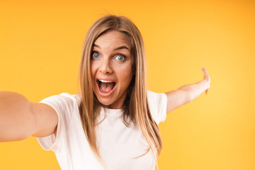 Fototapeta premium Image closeup of caucasian blond woman rejoicing at camera while taking selfie photo