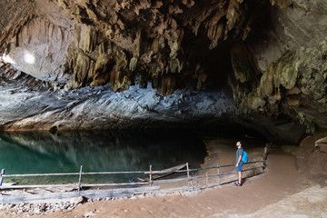 Human silhouette stands inside water cave in Konglor, Laos
