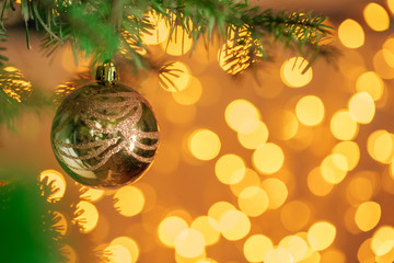 Christmas tree background with golden bauble on bokeh sparkling