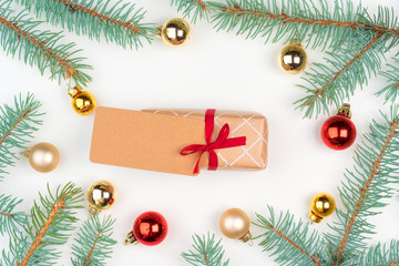 Christmas craft gift surrounded with pine tree branches and mini baubles