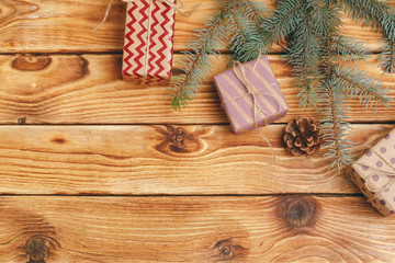 Christmas gifts with fir tree branches on wooden background