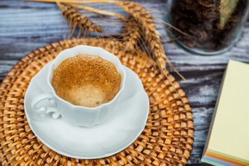 Tasse en porcelaine blanche osier et bloc notes sur table en bois vintage