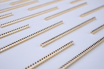 Golden cocktail straws on a white background. Holiday concept. Close-up.