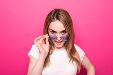 Fun and colorful. Young pretty happy woman posing against pink background