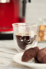 Glass cup of coffee at kitchen counter close up