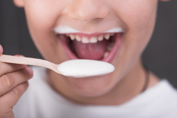 Boy eating organic yoghurt - 288643842