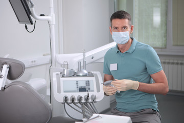 Dentist doctor man in the office. Face in the mask. The concept of prophylactic and dental...
