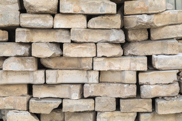 The background of a gray wall of uneven fascia. Bricks lie on top of each other with a flat layer without cement slurry