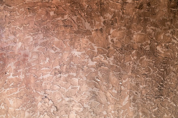 Background of a rouge plaster cement wall painted brown with paint.