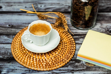 Tasse en porcelaine blanche osier et bloc notes sur table en bois vintage