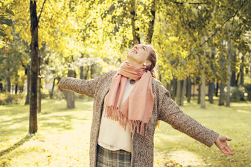 Beautiful  woman looking at autumn sunlight outdoors. Romantic g