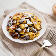 Homemade german Kaiserschmarrn pancake on a white plate, low angle view. Close-up.