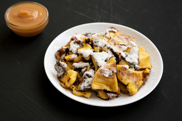 Homemade german Kaiserschmarrn pancake on a black surface, side view. Closeup.