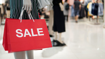 Unrecognizable woman holding shopping bags on blurred mall background
