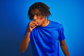 Naklejka premium Afro american man with dreadlocks wearing t-shirt standing over isolated blue background feeling unwell and coughing as symptom for cold or bronchitis. Healthcare concept.