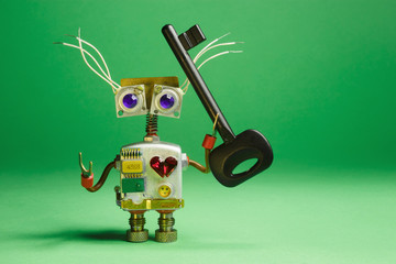 Funny robot toy with black key in his hand. Funny mechanical toy character.