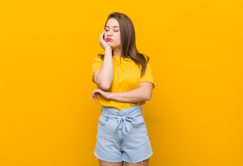 Young woman teenager wearing a yellow shirt who is bored, fatigued and need a relax day.