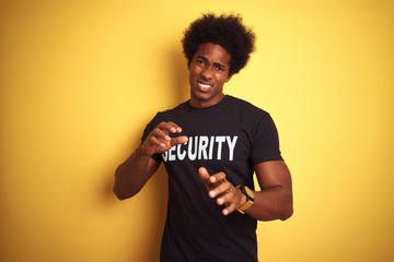 American safeguard man with afro hair wearing security uniform over isolated yellow background...