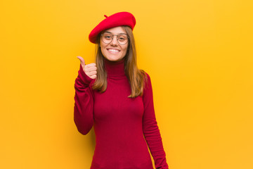 Young french artist woman smiling and raising thumb up