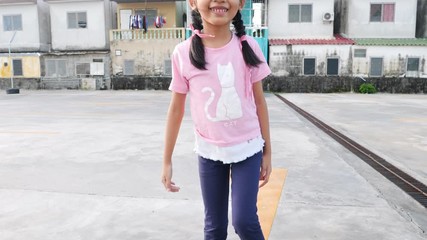Slow motion little Asian girl playing skateboard with happiness
