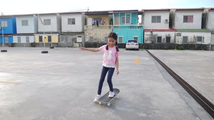 Slow motion little Asian girl playing skateboard with happiness