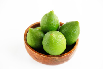 fruits of green natural lime lemon in a wooden brown a plate