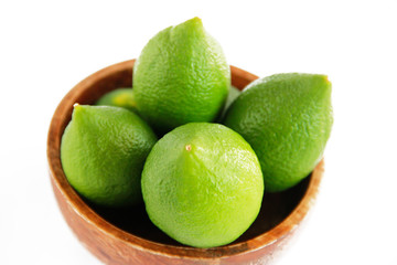 fruits of green natural lime lemon in a wooden brown a plate
