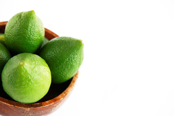 fruits of green natural lime lemon in a wooden brown a plate