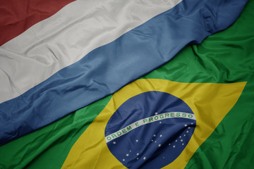 waving colorful flag of brazil and national flag of luxembourg.