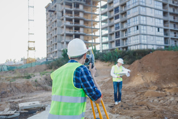 two engineers surveyor with construction equipment