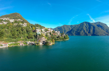 Fototapeta na wymiar Panorama aerial view of the lake Lugano, mountains and city Lugano, Ticino canton, Switzerland. Scenic beautiful Swiss town with luxury villas. Famous tourist destination in South Europe
