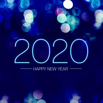 Happy new year 2020 with blue bokeh light sparkling on dark blue purple background,Holiday greeting card.