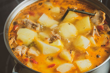 roast at home in a saucepan on the stove, close-up, stew and potatoes with spices