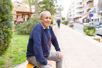 Handsome middle age senior man smiling cheerful, happy and positive sitting at the park