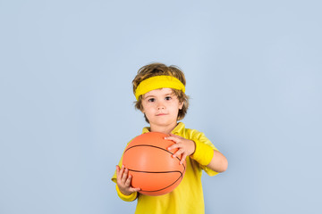 Boy in sportswear. Sport active. Hobby sport concept. Kid holds basketball. Sporty boy with ball. Sport, fitness, healthy lifestyle. Sport for children. Basketball player. Kid playing with basketball.