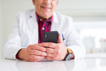 Close up of doctor hands using smartphone at the clinic and smiling