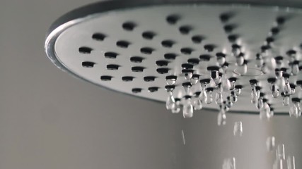 Close up shot water pouring from rain shower in the bathroom with dark and grain processed