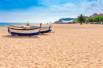 Fototapeta na wymiar Beach at seaside in Calella in Catalonia, Spain near Barcelona. Scenic old town with sand beach and clear blue water. Famous tourist destination in Costa Brava, perfect place for holiday and vacation