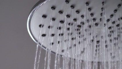 Slow motion close up shot water pouring from rain shower in the bathroom with dark and grain processed