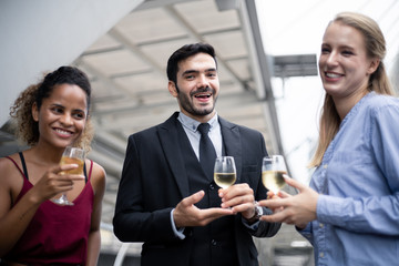 Group of business people celebrate by drinking wine.
