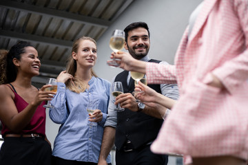 Group of business people celebrate by drinking wine.