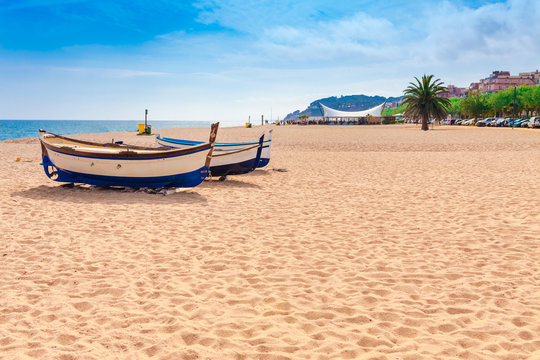 Beach at seaside in Calella in Catalonia, Spain near Barcelona. Scenic old town with sand beach and clear blue water. Famous tourist destination in Costa Brava, perfect place for holiday and vacation