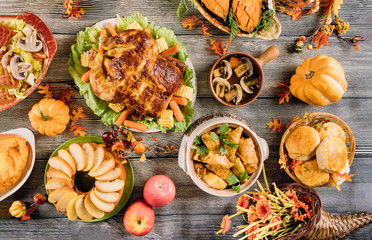 Roasted turkey garnished with many dishes on the table. Thanksgiving Day.